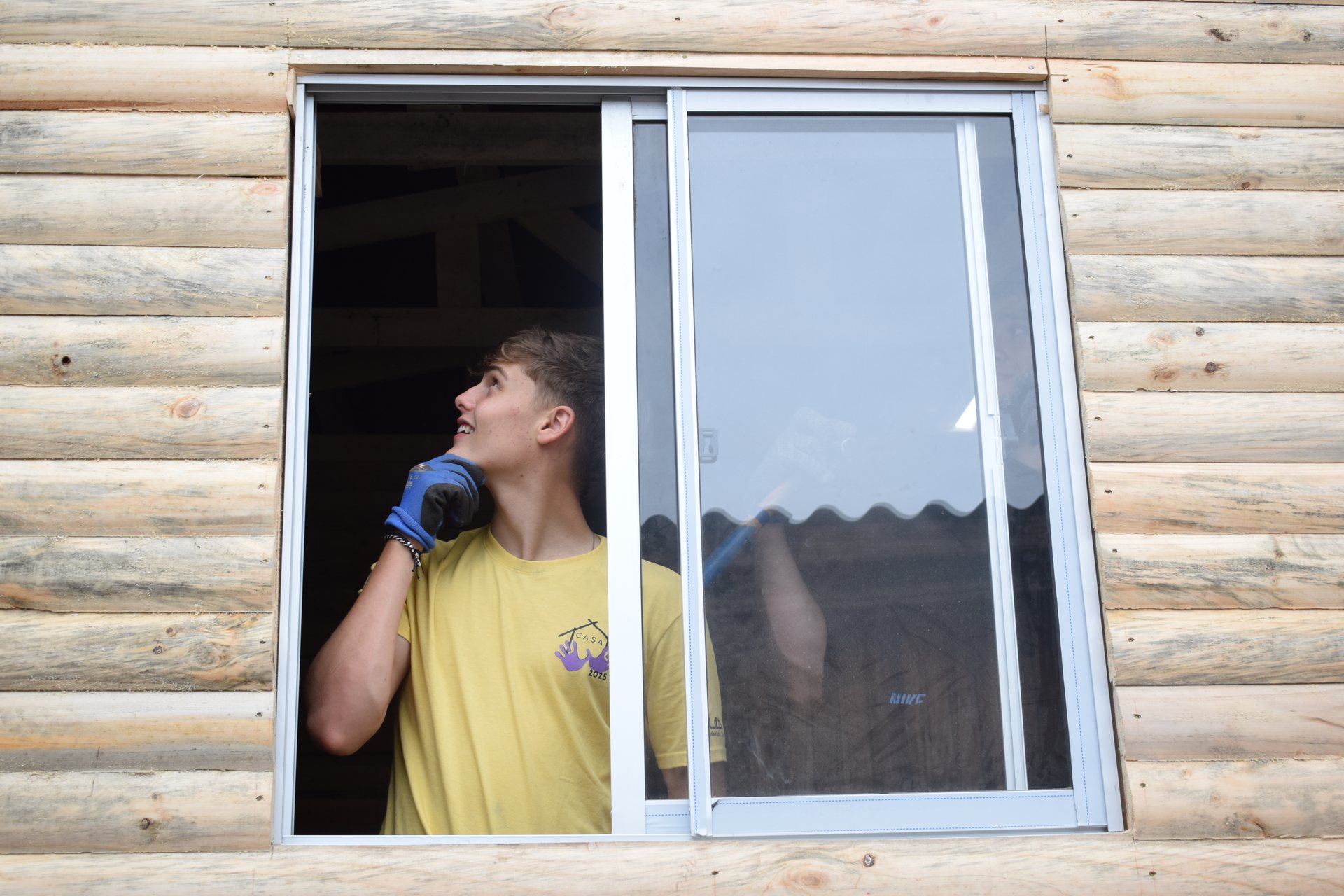 Alumno con polera amarilla trabajando junto a una ventana corredera de aluminio, Quillota verano 2025