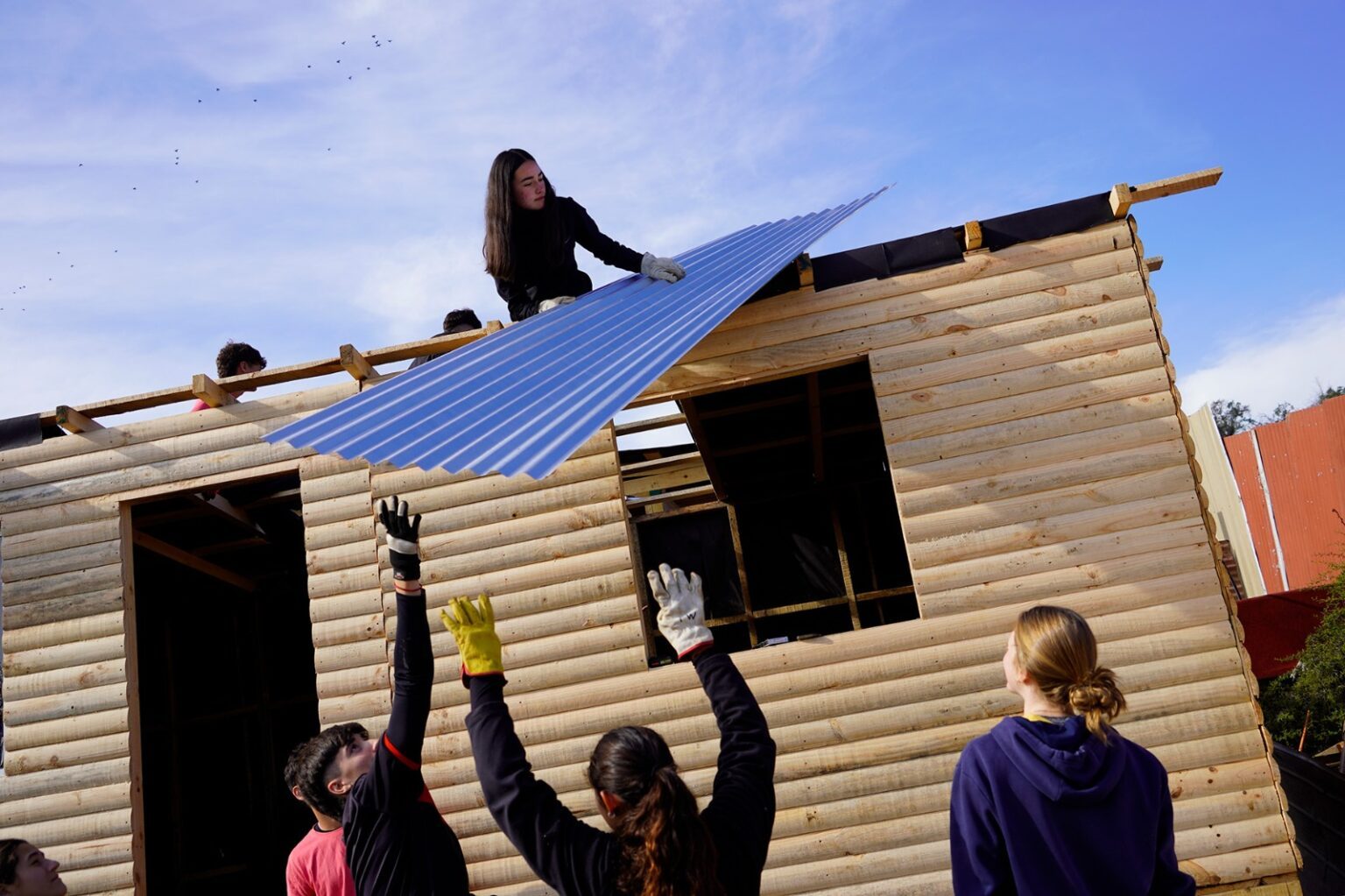 Alumna y su equipo instalando las planchas de zinc