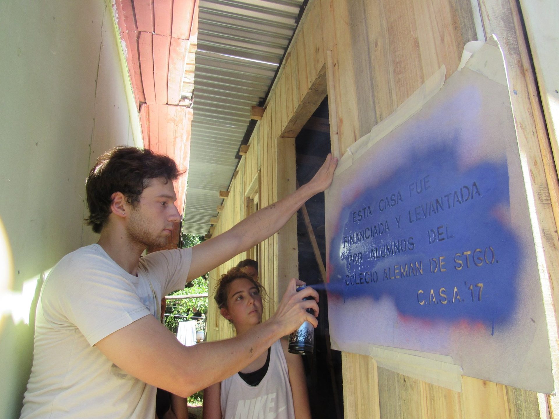Alumno pintando manos y placa azul, archivo C.A.S.A. 2016