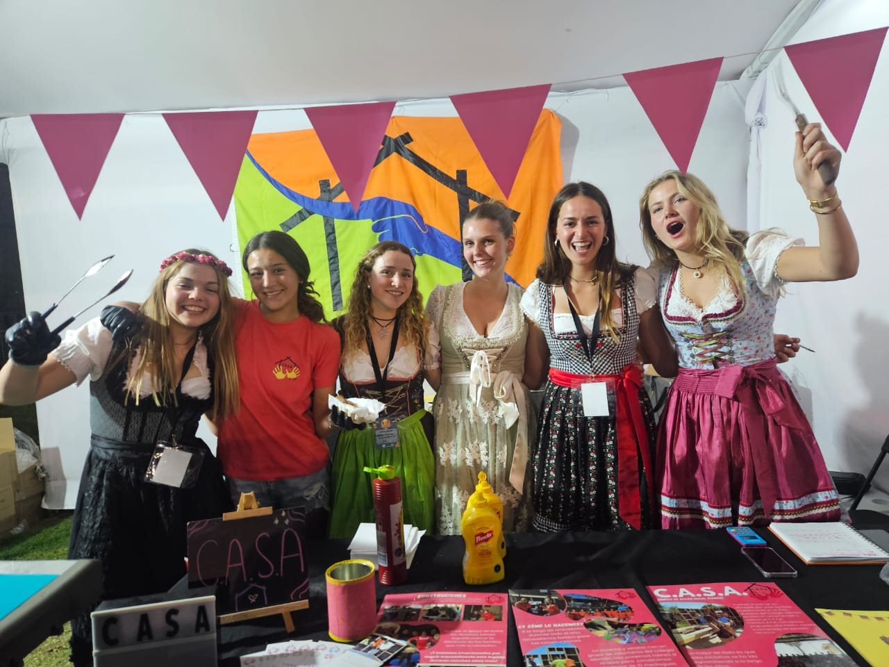 Voluntarias con trajes típicos en el stand con La Wurst, Oktoberfest Club Manquehue 2024